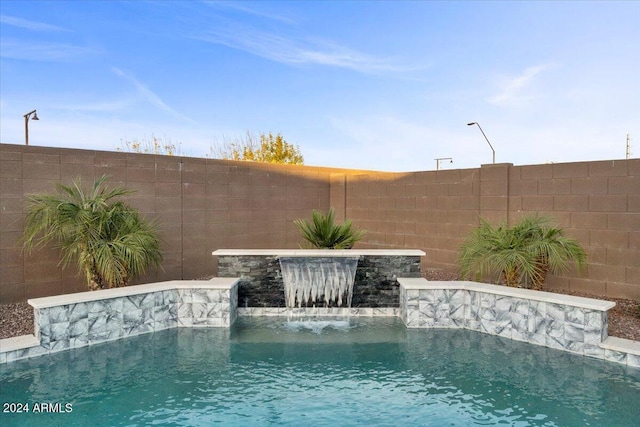 view of swimming pool with pool water feature