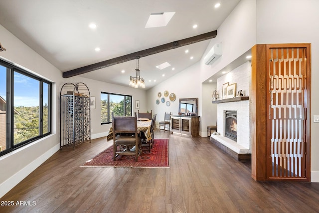 dining room with beamed ceiling, baseboards, a fireplace, wood finished floors, and an AC wall unit