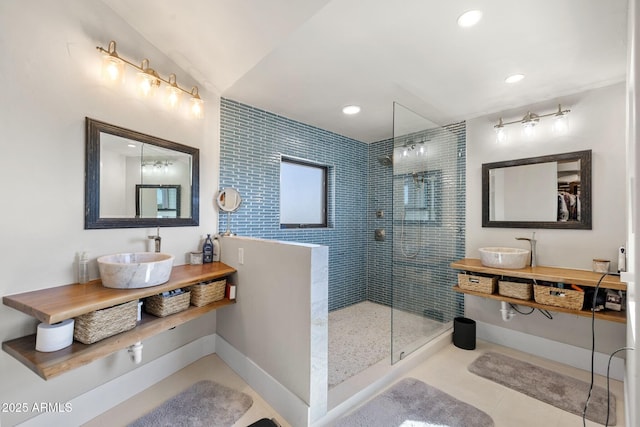full bathroom with baseboards, a sink, and a walk in shower