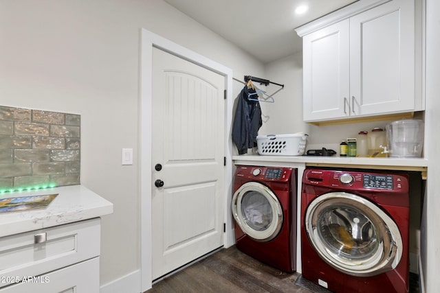 laundry area featuring washing machine and clothes dryer, cabinet space, and dark wood-style flooring