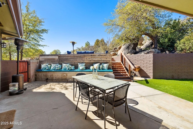 view of patio / terrace with a fenced backyard, stairway, an outdoor living space, and outdoor dining space