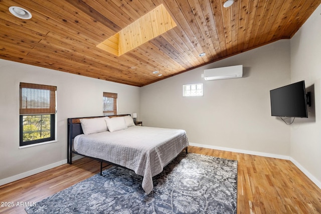bedroom with baseboards, lofted ceiling, wood finished floors, and a wall unit AC