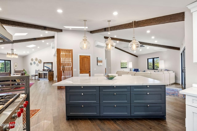 kitchen with a wall mounted air conditioner, lofted ceiling with beams, a healthy amount of sunlight, and open floor plan