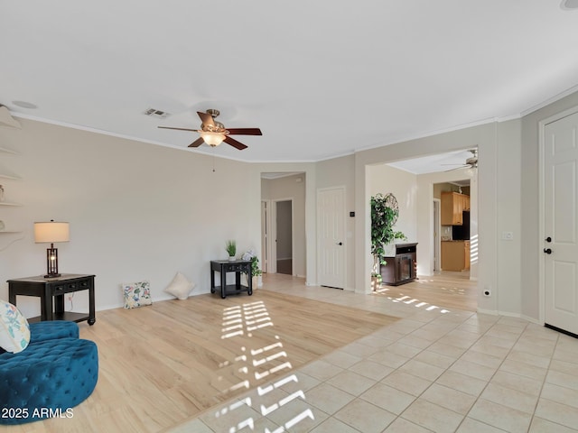 living area featuring ceiling fan, light tile patterned floors, and crown molding