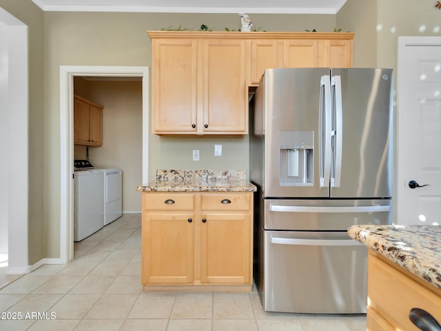 kitchen featuring separate washer and dryer, stainless steel fridge with ice dispenser, light brown cabinetry, and light stone countertops