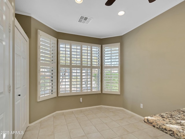 tiled spare room featuring ceiling fan and ornamental molding