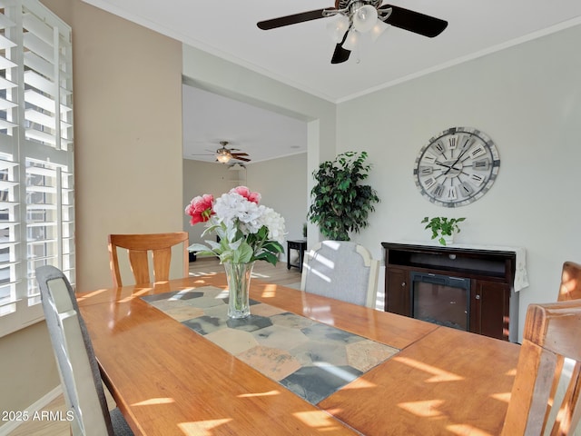 dining space with a fireplace and ornamental molding