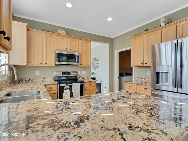 kitchen with washer and clothes dryer, sink, appliances with stainless steel finishes, and crown molding