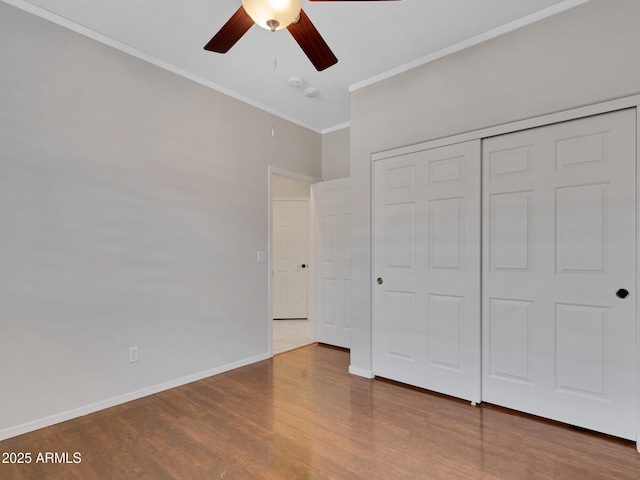 unfurnished bedroom featuring hardwood / wood-style flooring, a closet, ceiling fan, and ornamental molding