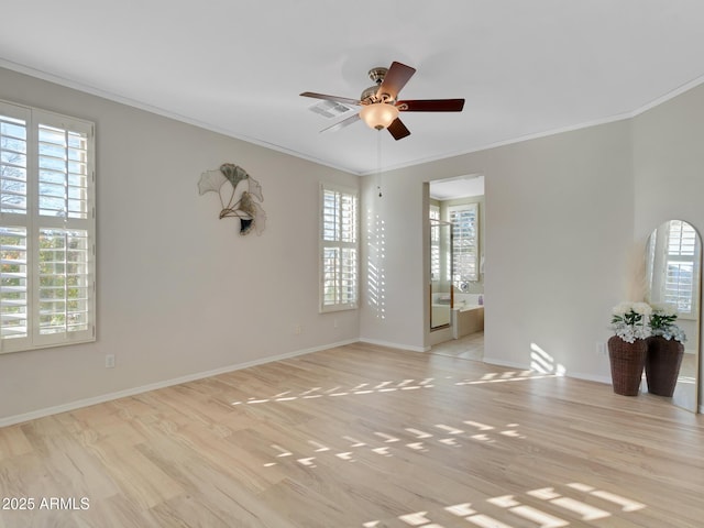 unfurnished room with light wood-type flooring, a wealth of natural light, and crown molding