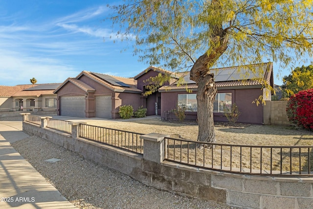 view of front of house featuring a garage and solar panels