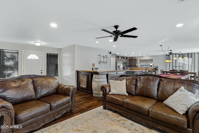 living room featuring ceiling fan and dark hardwood / wood-style flooring