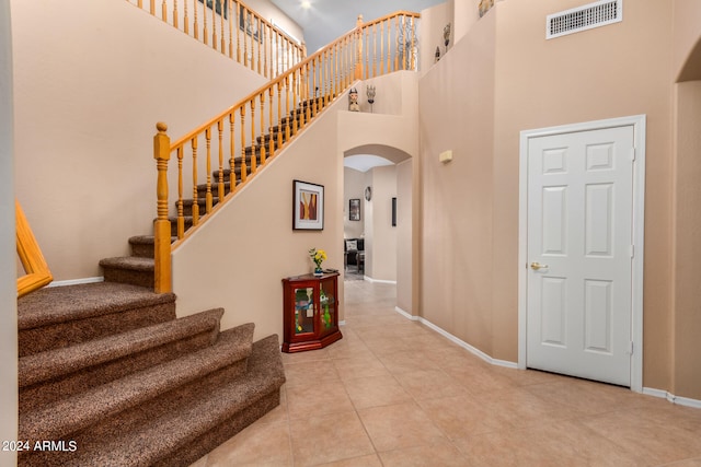 tiled entryway featuring a high ceiling