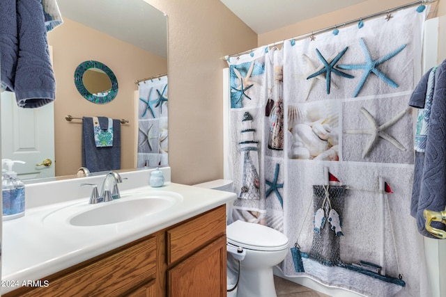 bathroom featuring curtained shower, vanity, toilet, and tile patterned floors