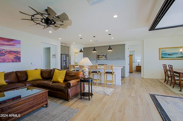 living room with ceiling fan and light hardwood / wood-style floors