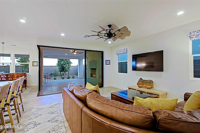 living room featuring ceiling fan and light hardwood / wood-style floors