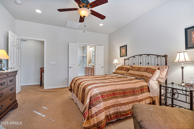 bedroom with ensuite bath, light colored carpet, and ceiling fan