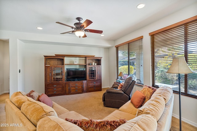 carpeted living room with ceiling fan