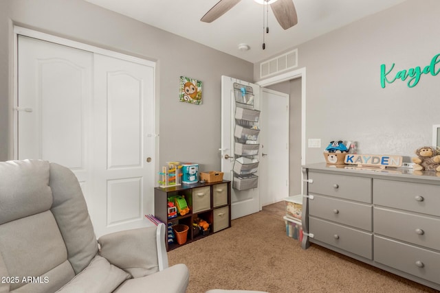 bedroom featuring light colored carpet, a closet, and ceiling fan