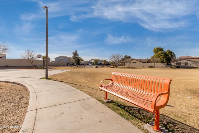 view of property's community featuring a yard and basketball hoop