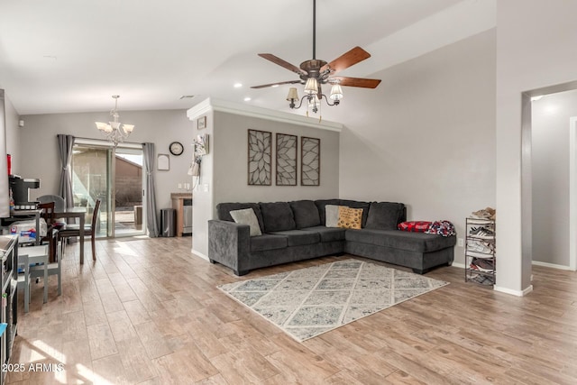 living room featuring vaulted ceiling, ceiling fan with notable chandelier, and light hardwood / wood-style flooring