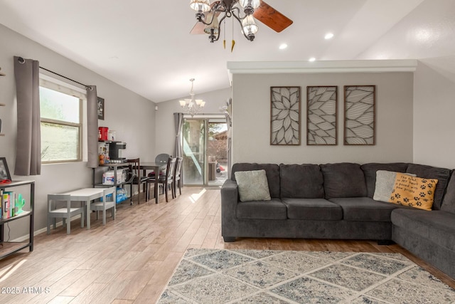 living room with lofted ceiling, ceiling fan with notable chandelier, and wood-type flooring