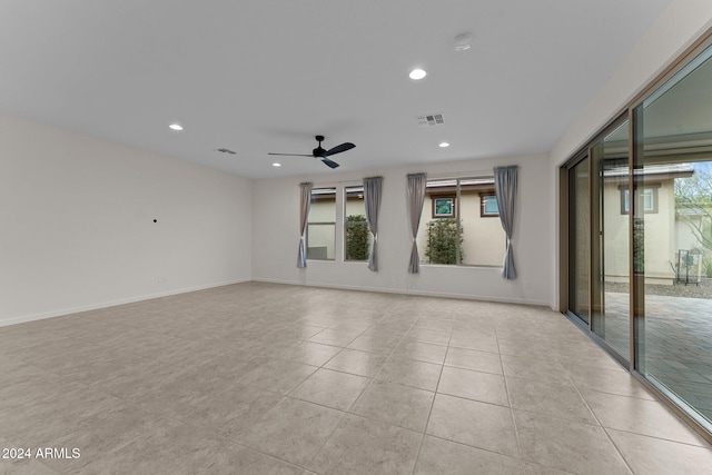 empty room with ceiling fan and light tile patterned floors