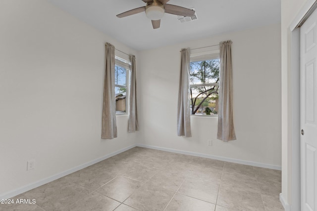 tiled empty room with ceiling fan