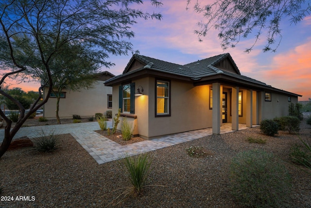 property exterior at dusk with a patio area