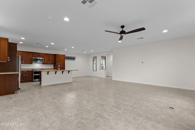 unfurnished living room featuring ceiling fan and sink