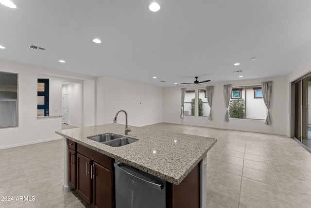 kitchen with stainless steel dishwasher, dark brown cabinetry, ceiling fan, sink, and an island with sink