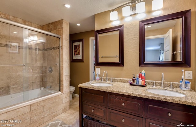 full bathroom featuring bath / shower combo with glass door, tile patterned floors, vanity, and toilet