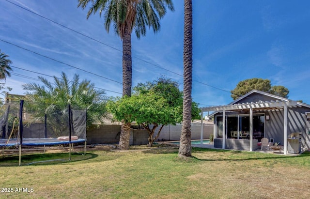 view of yard with a trampoline and a pergola