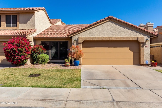 view of front of home with a tiled roof, an attached garage, driveway, and stucco siding