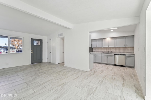 kitchen featuring gray cabinetry, dishwasher, sink, vaulted ceiling with beams, and decorative backsplash