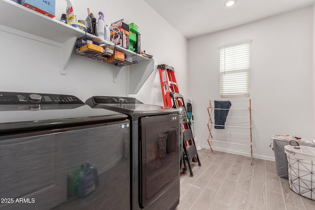 laundry area featuring washing machine and clothes dryer and light hardwood / wood-style flooring