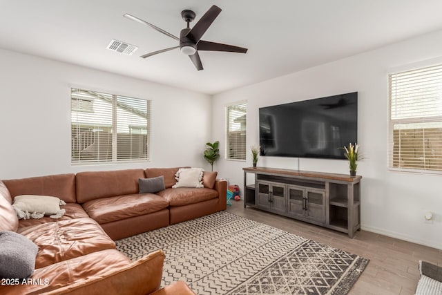 living room with ceiling fan, a healthy amount of sunlight, and light wood-type flooring