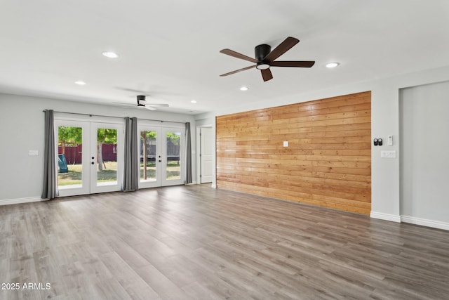 unfurnished living room with french doors, recessed lighting, a ceiling fan, wood finished floors, and baseboards