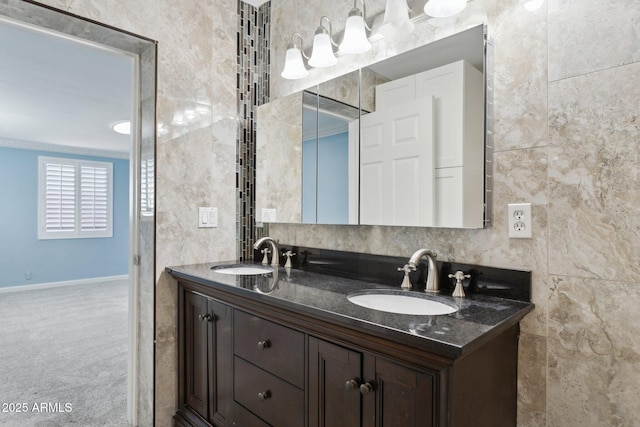 full bath featuring double vanity, tile walls, and baseboards