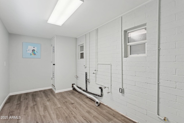 laundry area featuring wood finished floors and baseboards