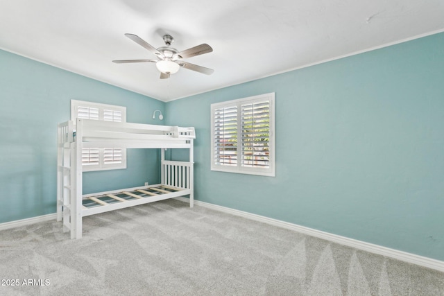 unfurnished bedroom featuring carpet, baseboards, ceiling fan, and lofted ceiling