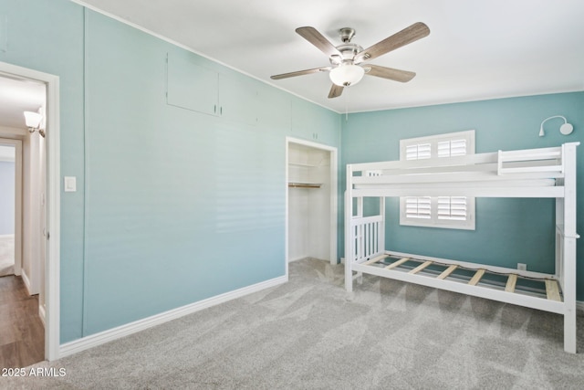 unfurnished bedroom with carpet floors, a closet, a ceiling fan, and baseboards