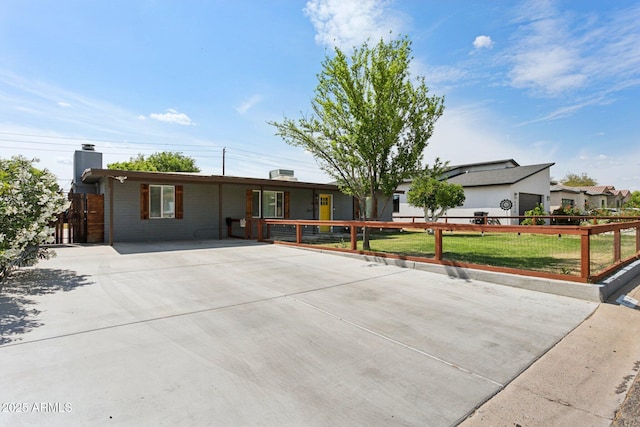 ranch-style home with a chimney and driveway