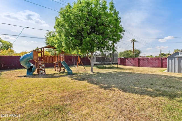 view of yard featuring a trampoline, a playground, and a storage unit