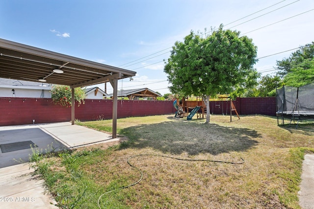 view of yard featuring a trampoline, a playground, and a patio area