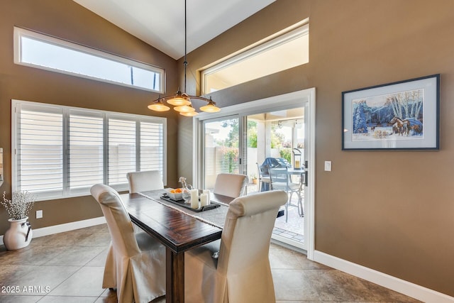 tiled dining room featuring lofted ceiling