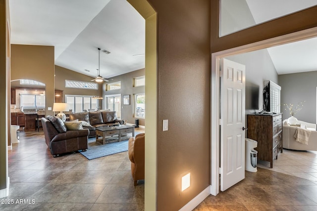 hall with high vaulted ceiling and light tile patterned flooring