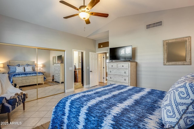 tiled bedroom with vaulted ceiling, ceiling fan, and a closet