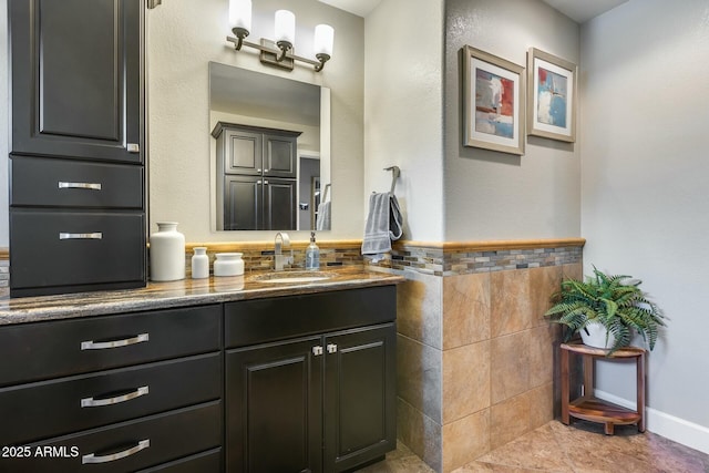 bathroom with vanity and tile walls