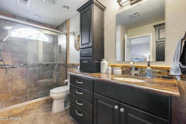 bathroom featuring walk in shower, tile walls, vanity, and toilet